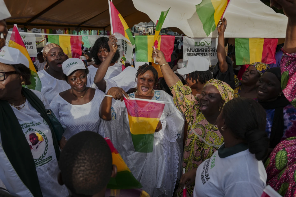Supporters Of The Constitutional Referendum Wave Guinea Flags With Optmistic Expressions And Cheers Webp