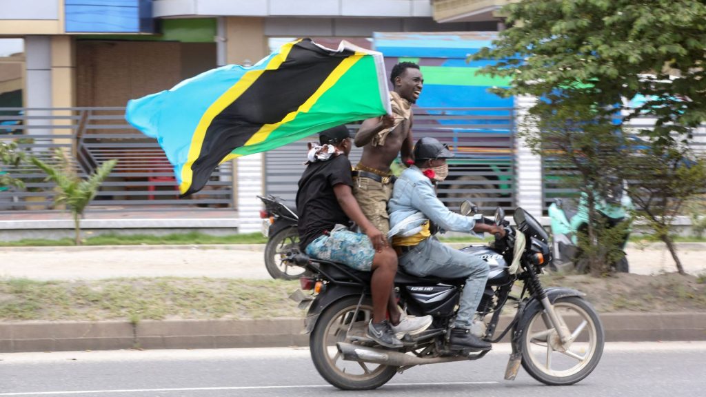 Some Youths Were Protesting While On A Bike With A Tanzanian Flag