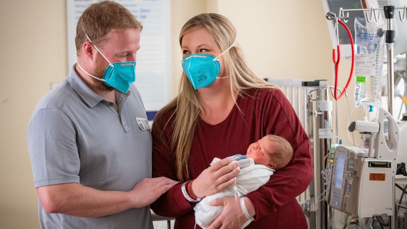 Parents Of The Baby Expressing Delightment As They Hold Onto Their Child